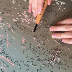 Chon Yue Zen, using lino cutting tools to carve his paintings. Image from Luxuo